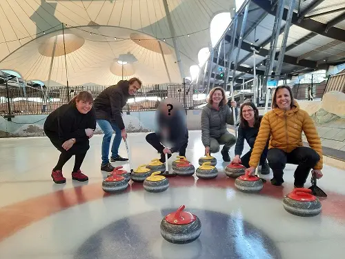 het team van de Rekenkamer Oost-Nederland in actie op de ijsbaan, ze maken kennis met curling